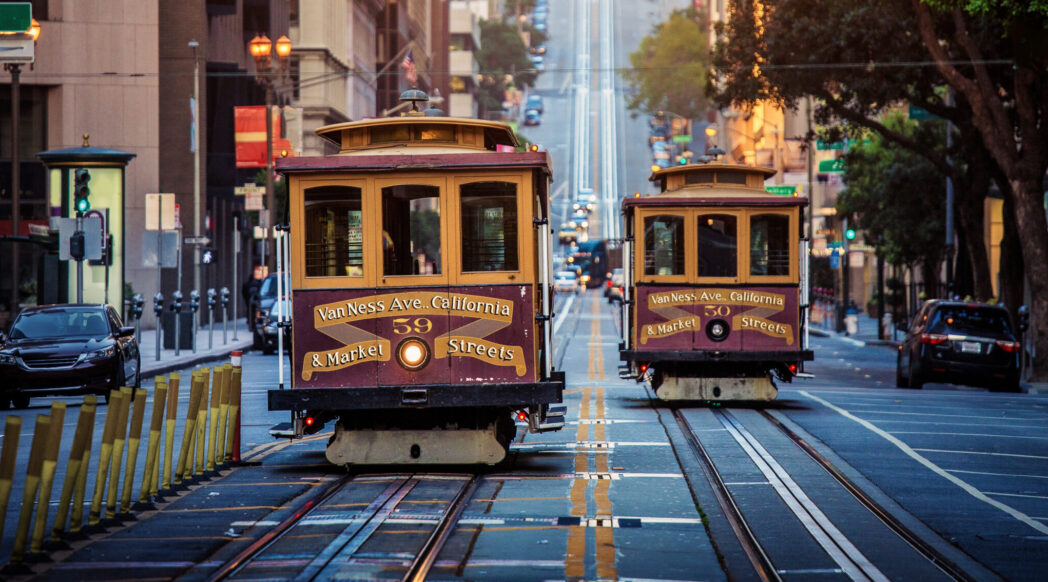 Old-fashioned San Francisco street cars ride around Mission District at sunrise