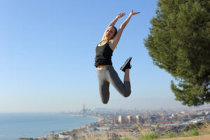 A woman on a run is jumping with joy as she experiences runner's high