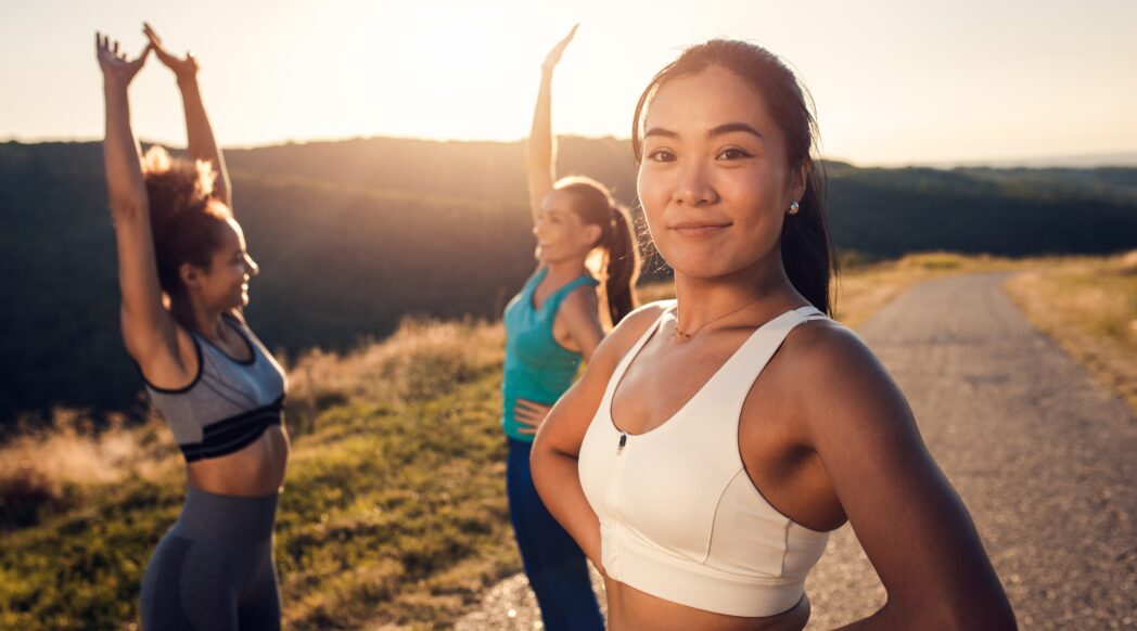 Three young women running on a trail in the late afternoon. Stick with your goals.